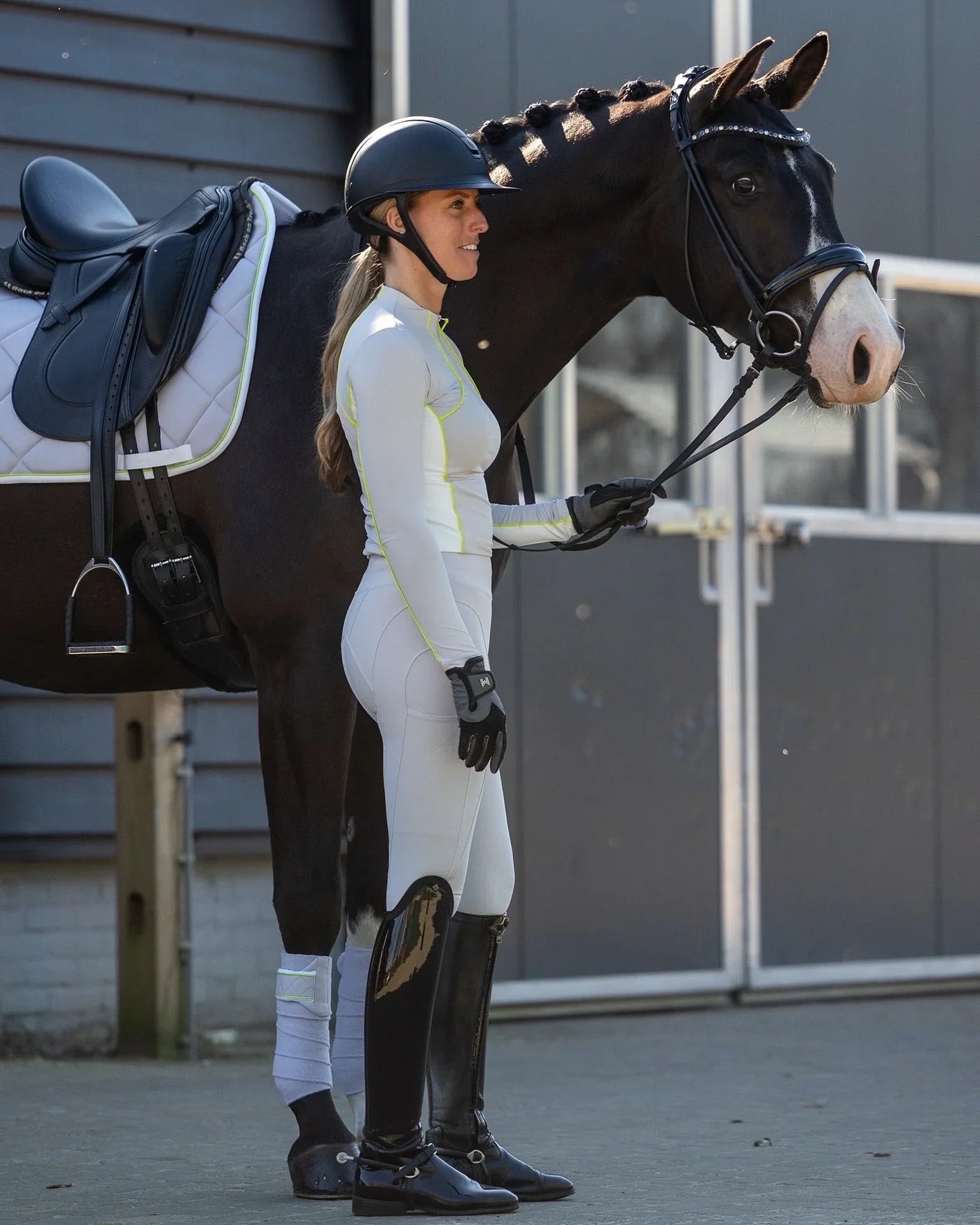 Reiterin führt gesattelte Pferd neben sich, First Ride Vibes: So viel kostet der Reitstart & das brauchst du wirklich.