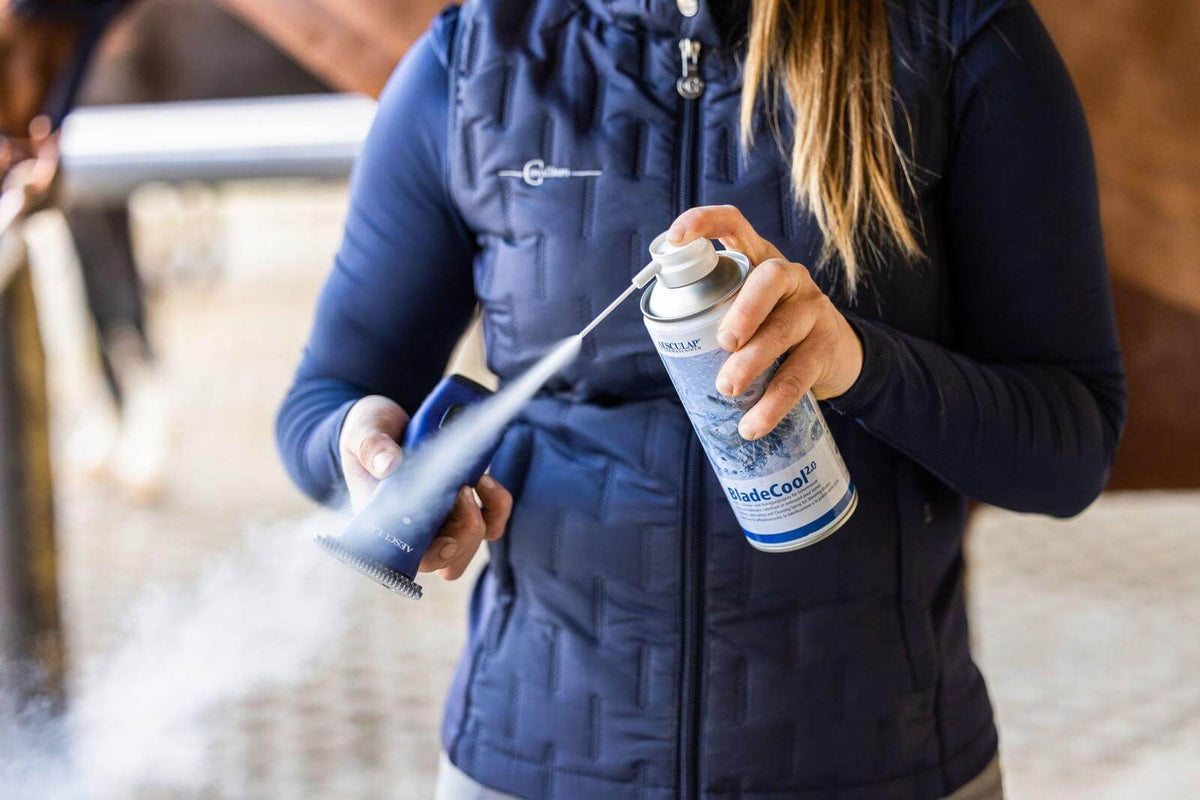 Aesculap Schermaschinen Kühlspray BladeCool 2.0, Produkt in der Hand einer Person beim Besprühen einer Schermaschine.