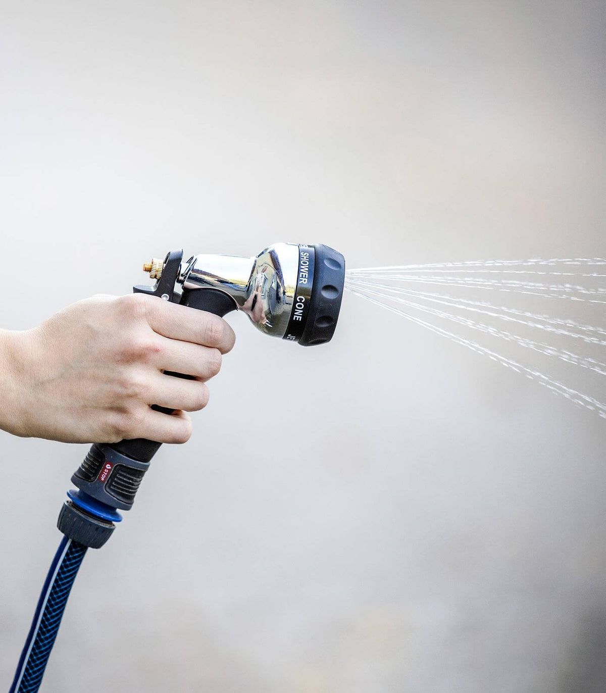 Waldhausen Abspritzbrause Komfort mit Messingeinsatz, Detailaufnahme in der Hand mit Wasserstrahl.