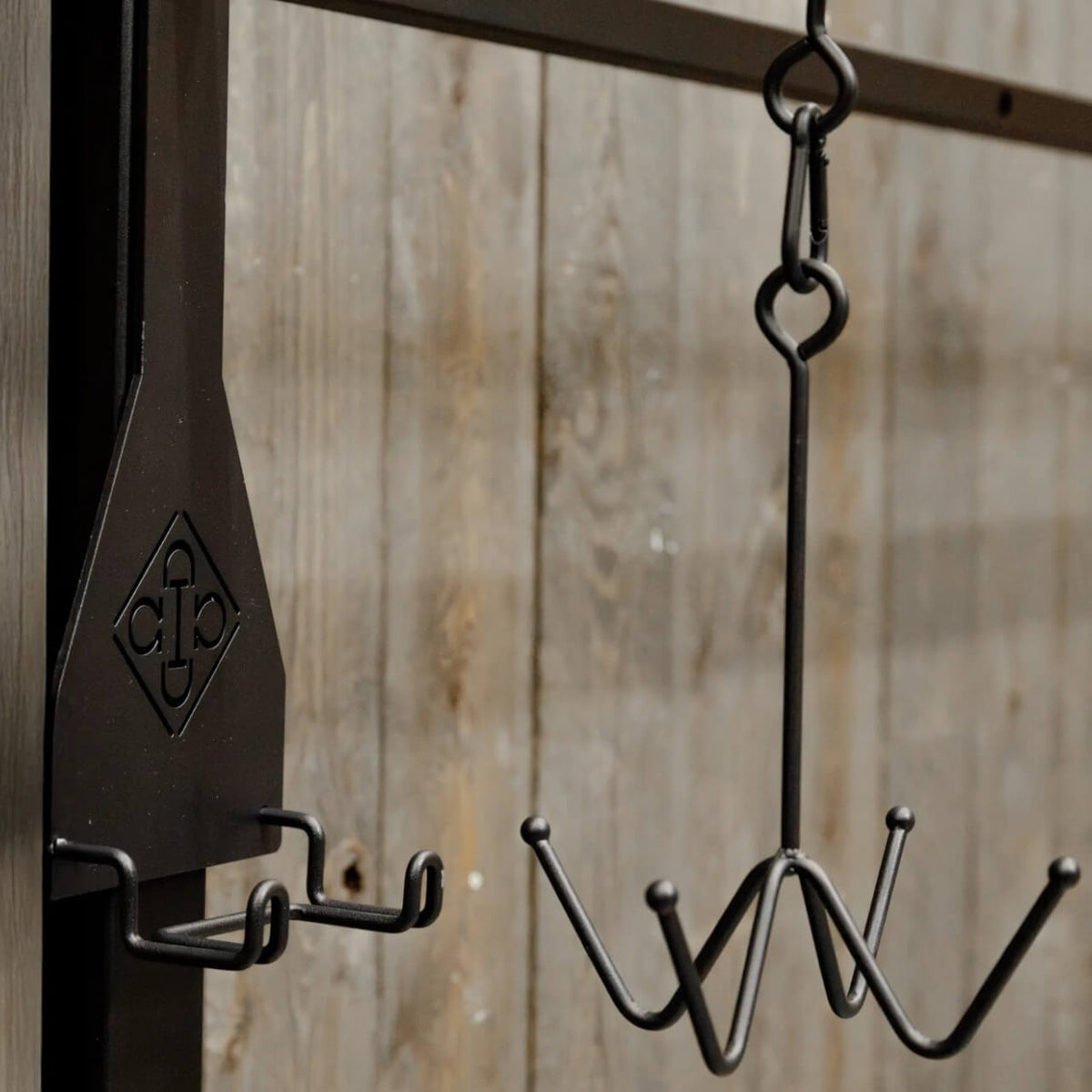 Grooming Deluxe Trensenhalter mit 4 Haken Hakenbefestigung, Schwarz, Detailaufnahme an der Stallwand.