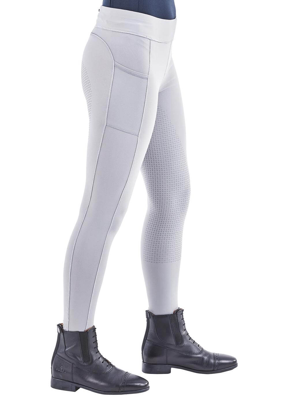 Reitleggings Damen Full-Grip Passion, Grau, an Reiterin im Sattel mit Reitstiefeln.
