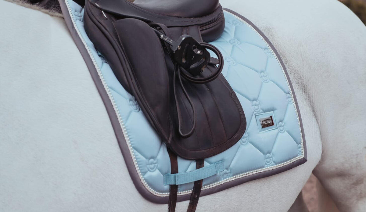 Equestrian Stockholm Dressurschabracke Ice Blue Pearl, Ice Blue, auf weißem Pferd unter dem Sattel.