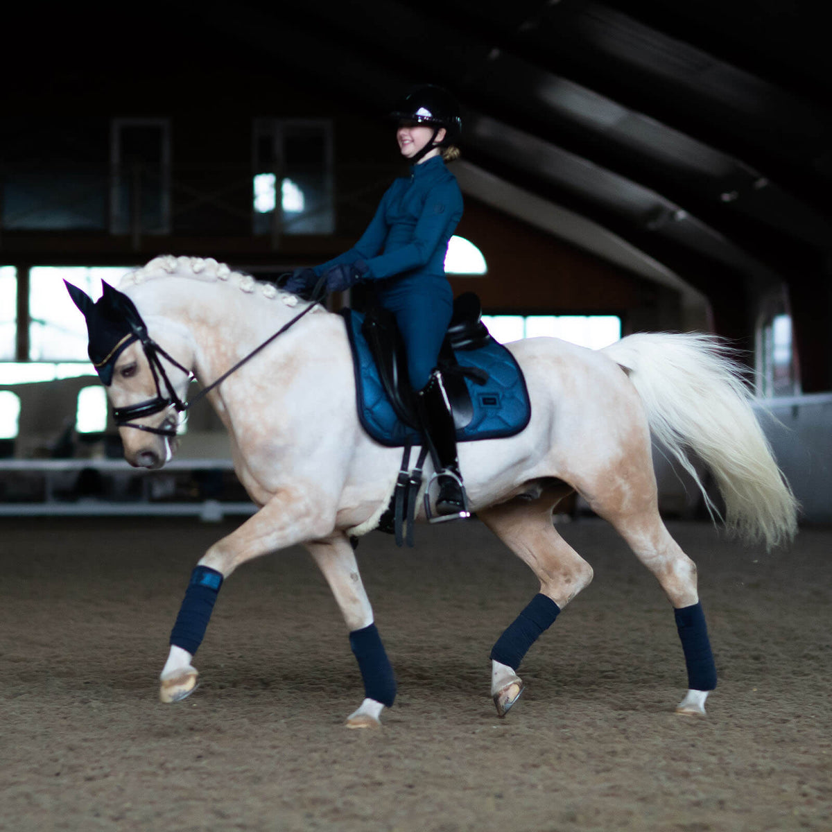 Dressurschabracke Blue Meadow Glimmer Schabracke, Blau, Reiterin auf Pferd in der Halle.
