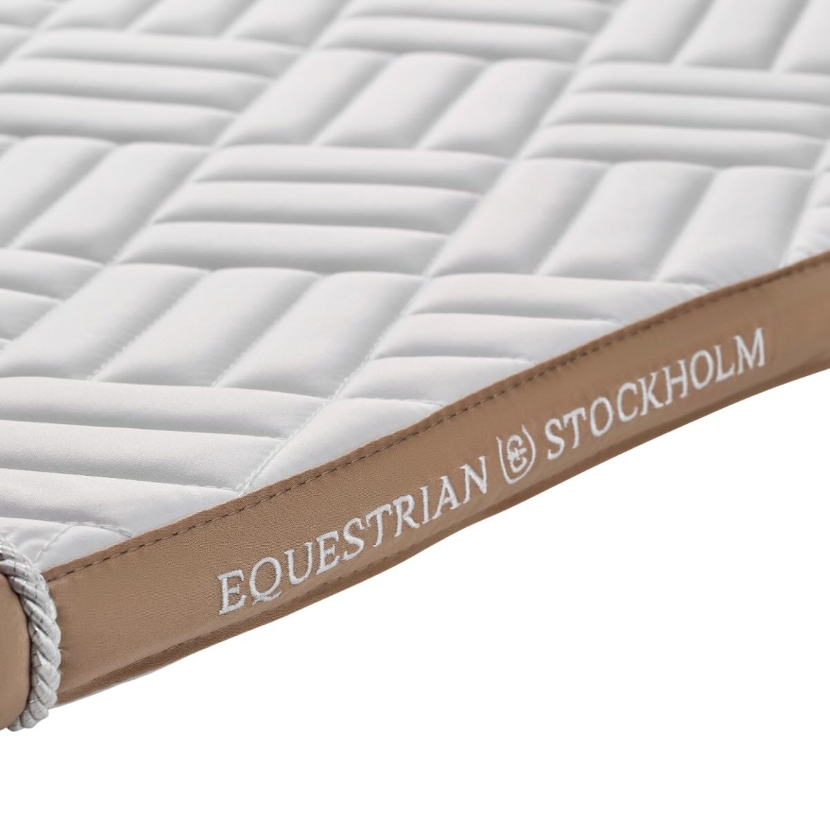 Springschabracke Modern White Sand Kollektion Schabracke, Detailaufnahme der weißen Springschabracke mit braunem Rand.