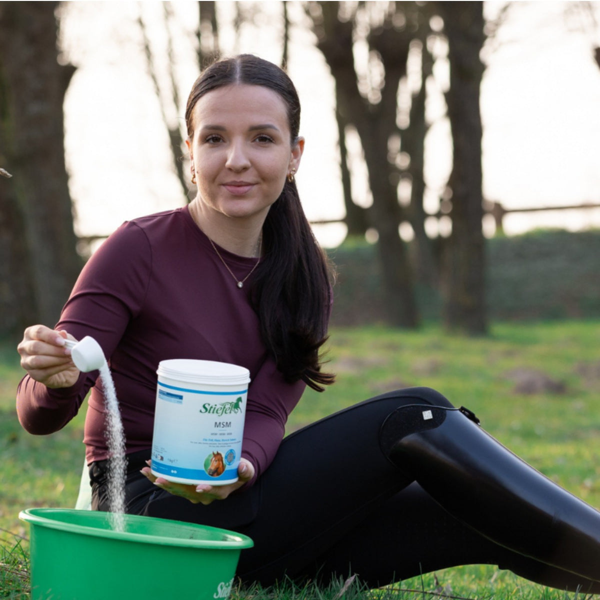 Stiefel MSM-Pulver, Produkt mit Person beim Dosieren neben Eimer.