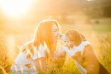 Junge Frau kniet mit Beagle im Gras und berührt seine Nase, Dein bester Freund und Partner auf vier Pfoten. Bist du auch auf den Hund gekommen? Wir zeigen dir unsere liebsten Hunderassen!