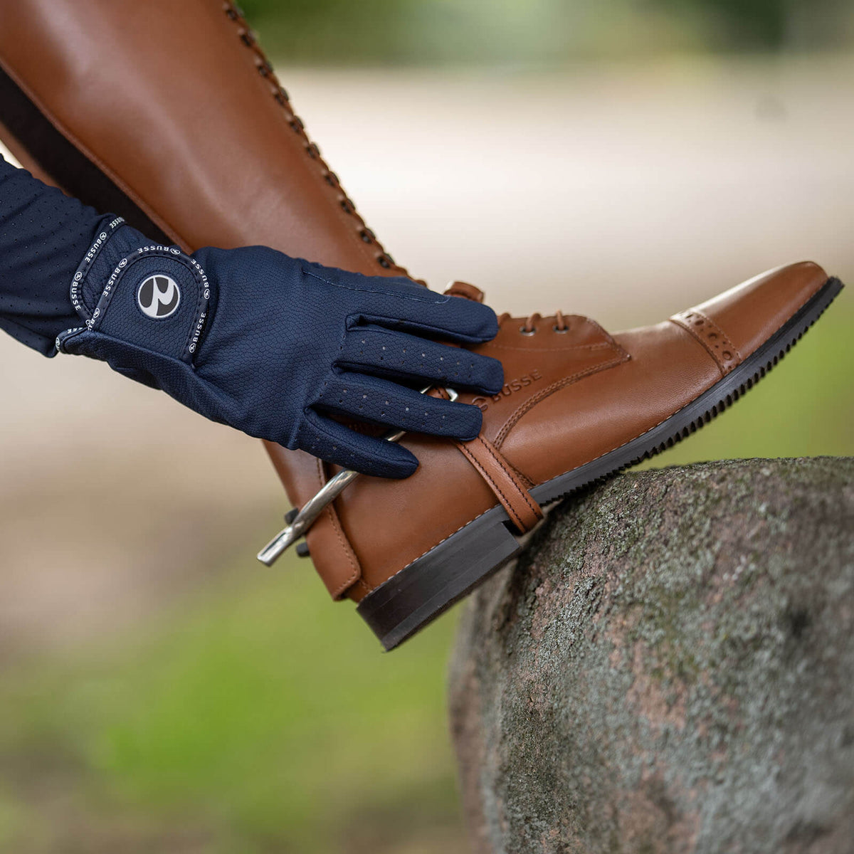 Reithandschuhe Unisex Casual GP Ganzjahreshandschuh, Navy, Hand mit Reithandschuh am braunen Reitstiefel.