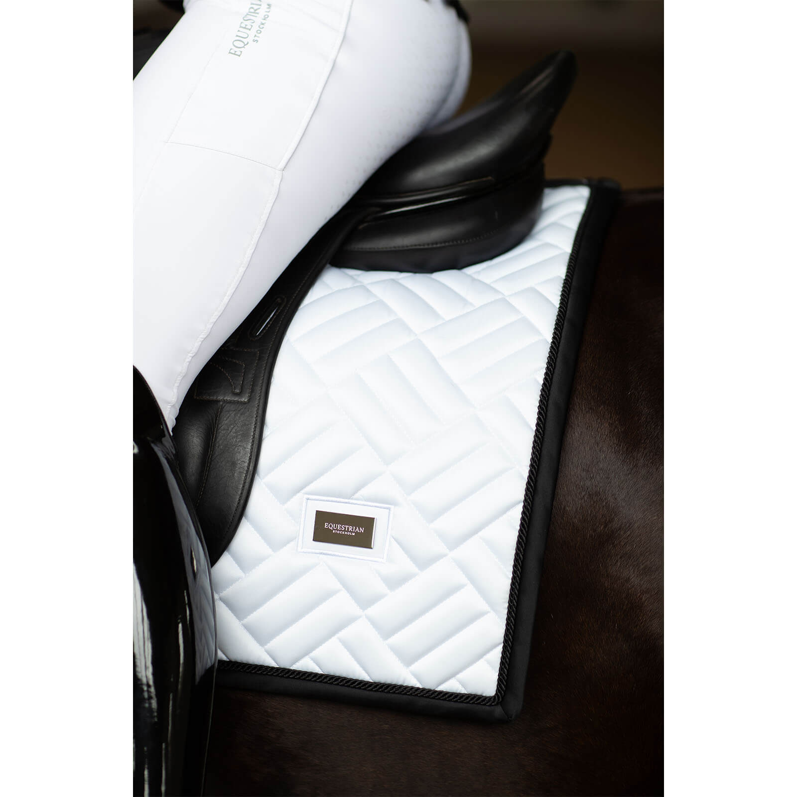 Equestrian Stockholm Schabracke Dressur Modern White Black Edition Dressurschabracke, White Black Edition, am Pferd unter dem Sattel.