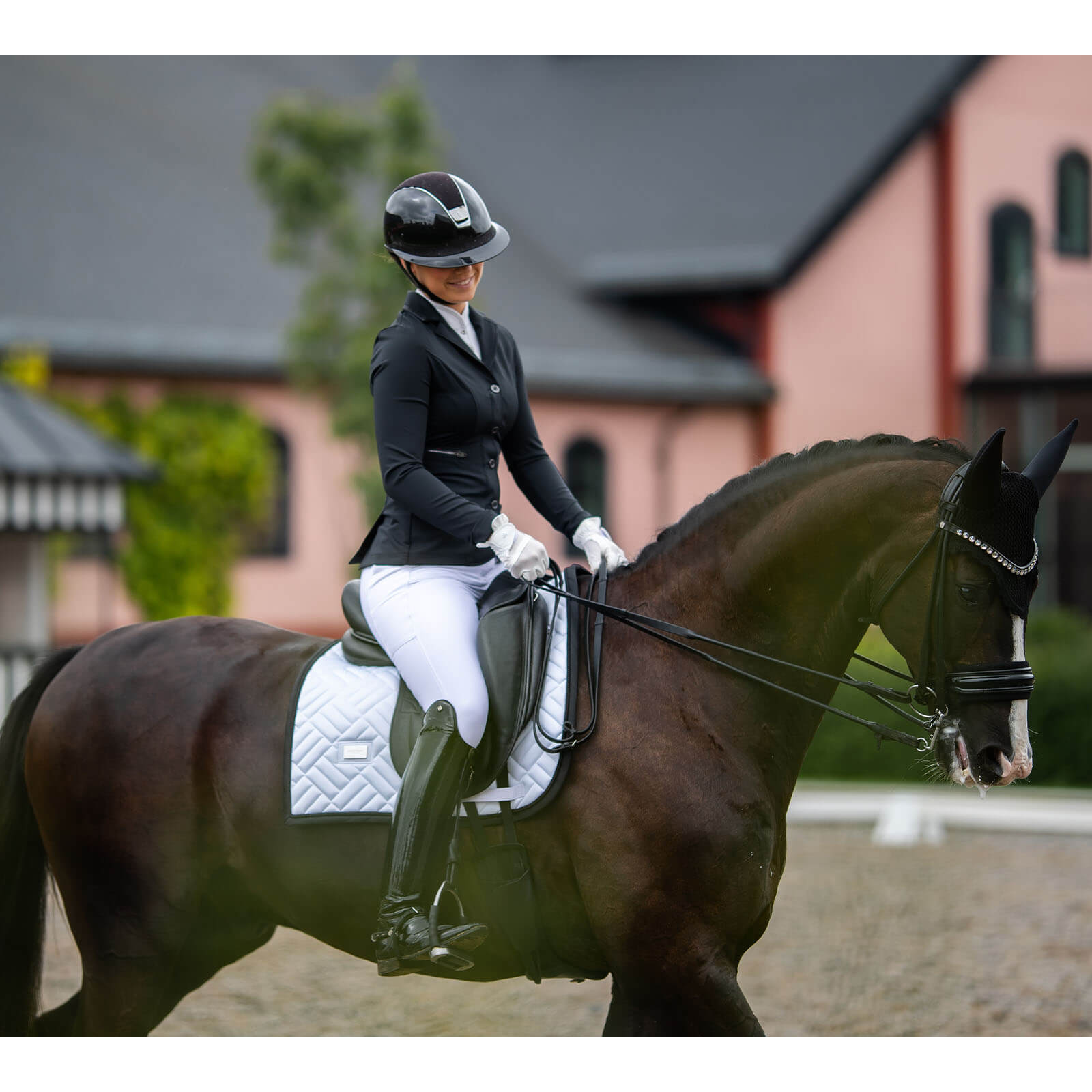 Equestrian Stockholm Schabracke Dressur Modern White Black Edition Dressurschabracke, White Black Edition, Reiterin auf Pferd im Dressurviereck.