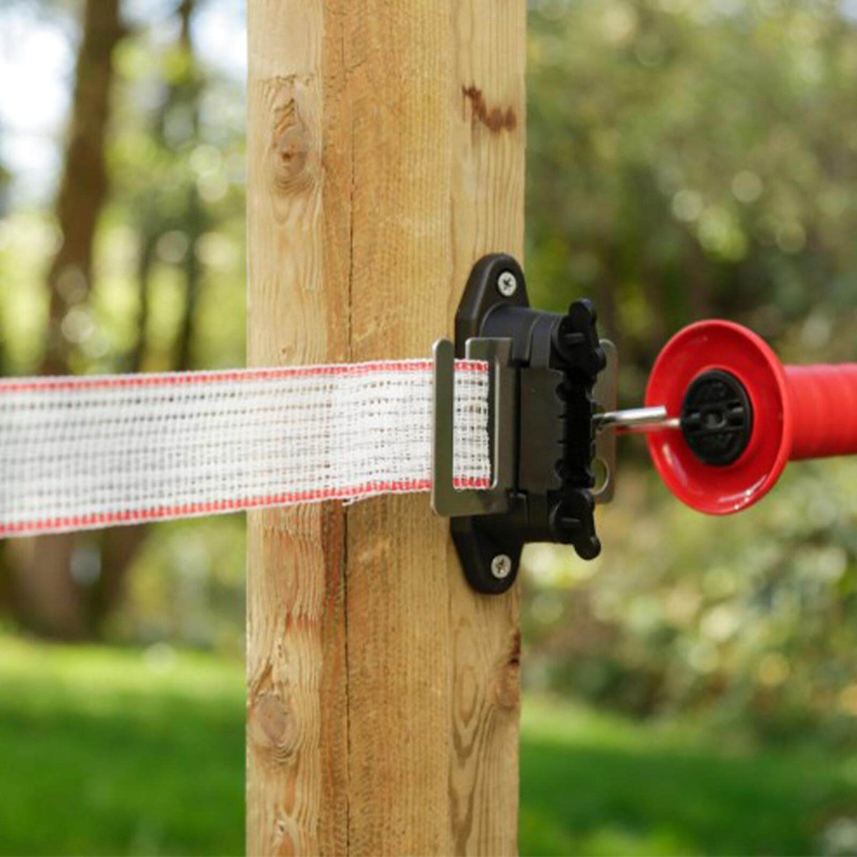 KERBL Eck-/Streckenisolator Premium, schwarz-rot, Detailaufnahme am Zaunpfosten mit Zaunband.
