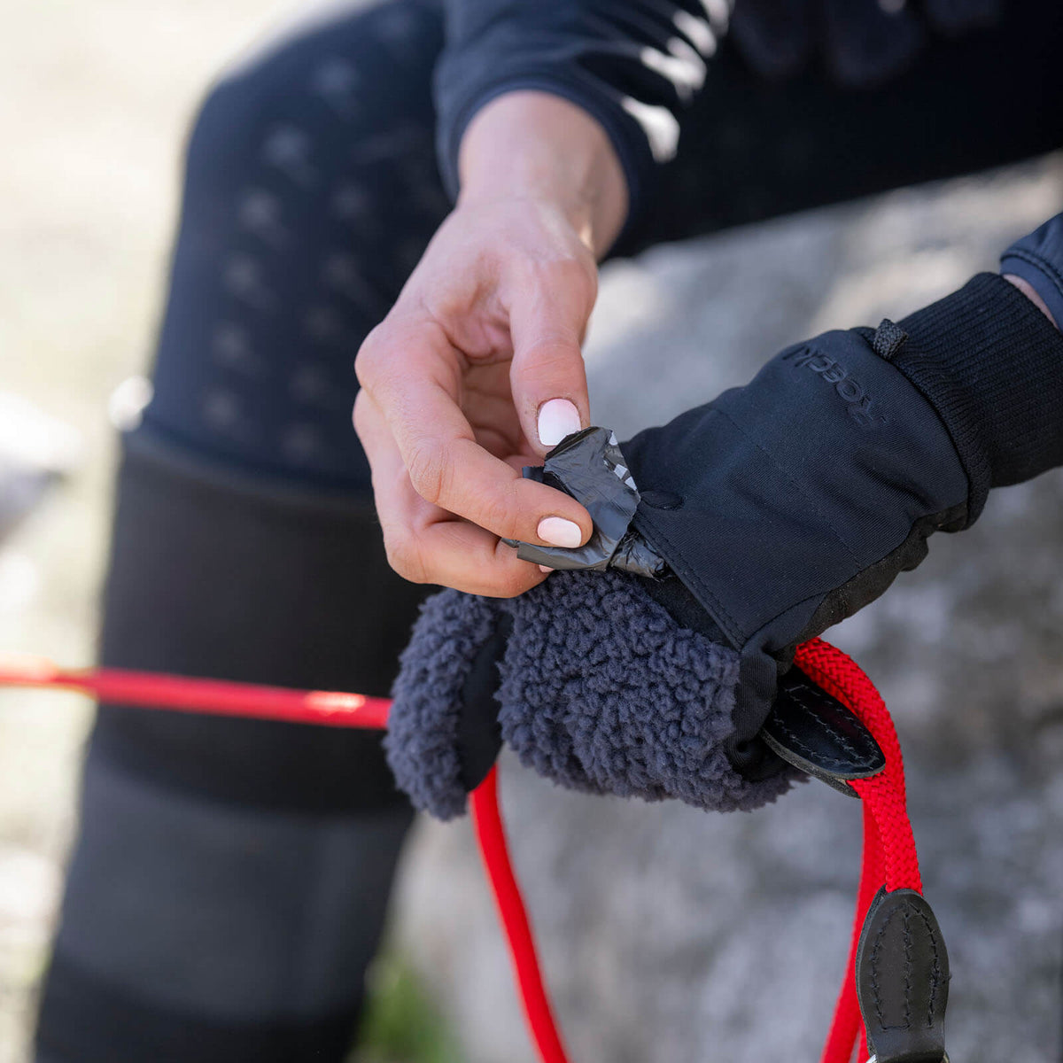 Roeckl Winterreithandschuh Unisex Dog-Walker Neuberg Winter Stallhandschuh, schwarze, Detailaufnahme an Hand mit Hundeleine.