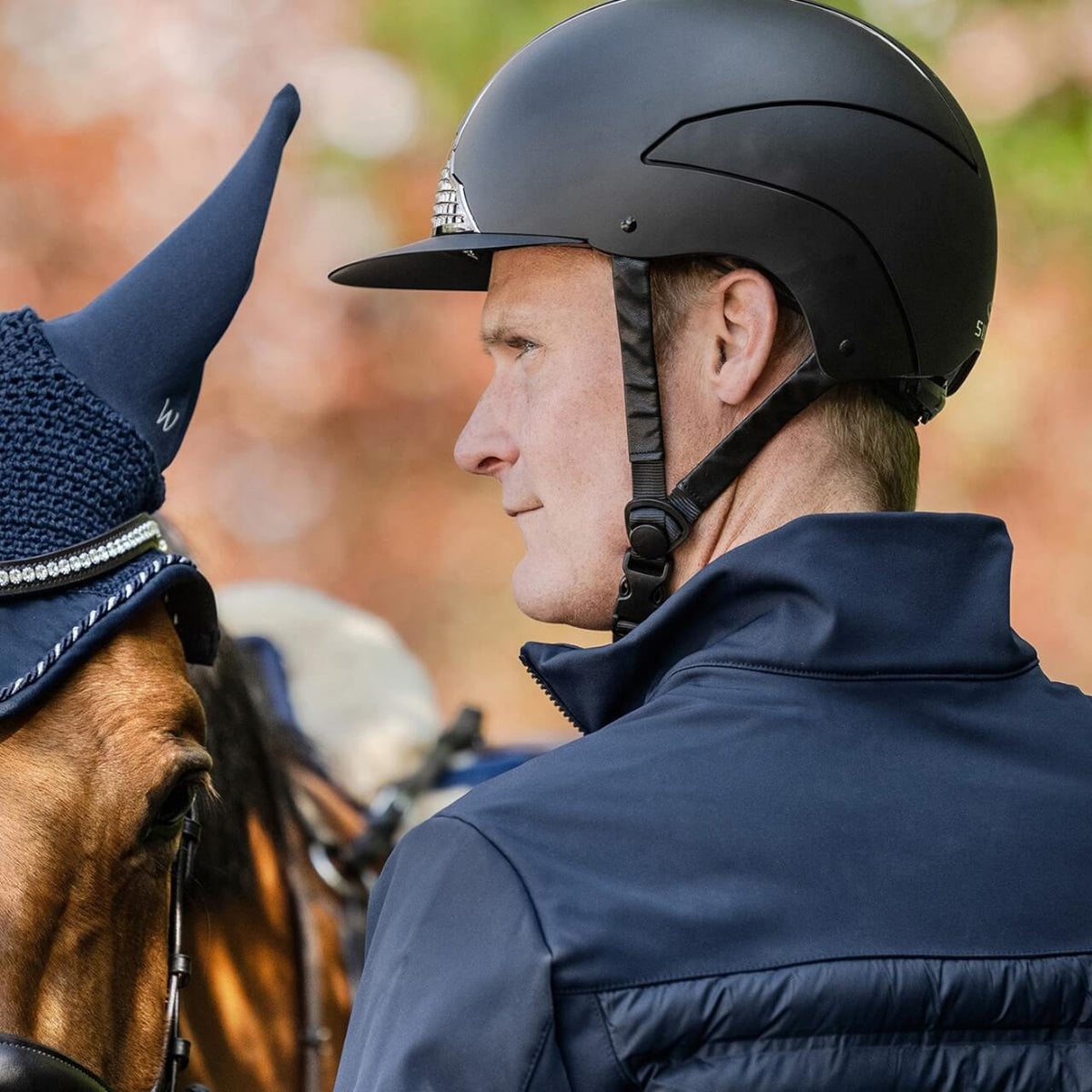 Reithelm Unisex H24 Chrome, Schwarz, Detailaufnahme an Reiter mit Pferd.