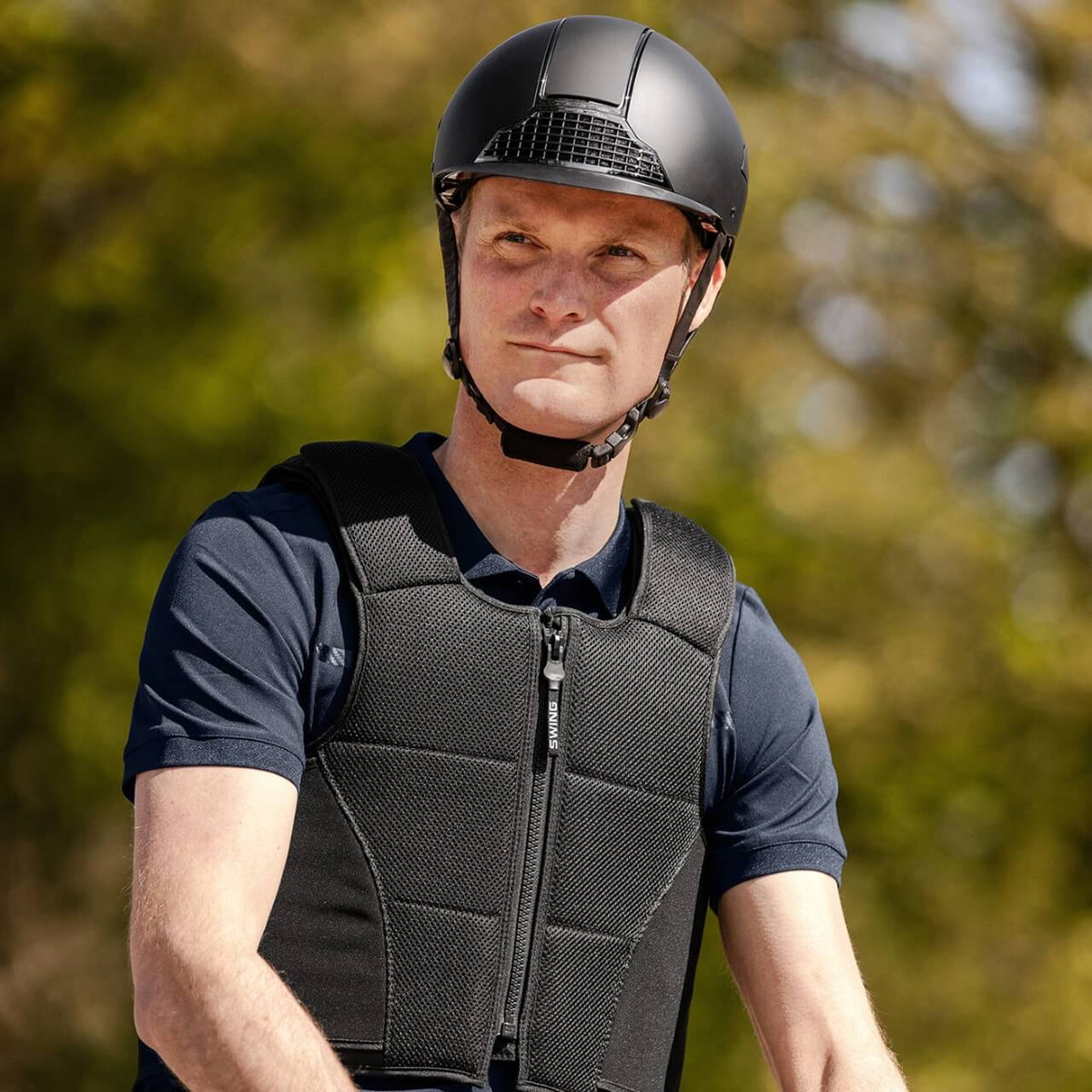 Reithelm Unisex H24 Chrome, Schwarz, Person trägt den Helm im Freien.