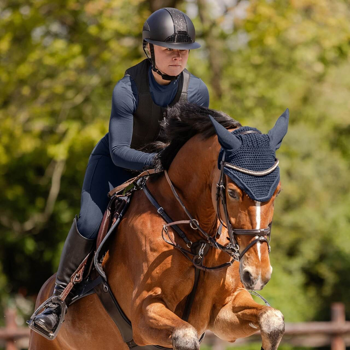 Reithelm Damen H24 Lady Shine, schwarz, Reiterin reitet auf braunem Pferd.
