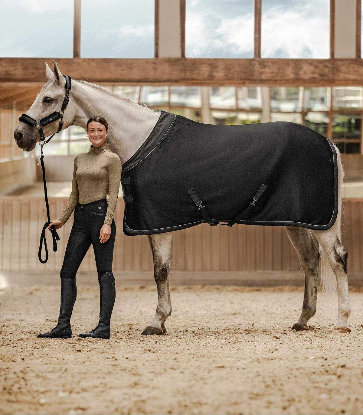 Jerseyabschwitzdecke Phoenix, Schwarz, an Pferd in der Reithalle.
