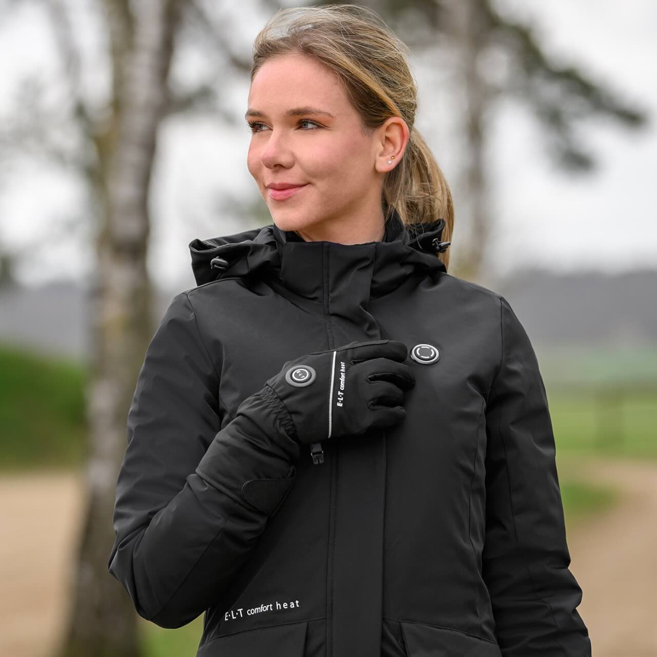 E.L.T Heizparka Damen Comfort Heat Heizjacke, Schwarz, Frau trägt das Produkt im Freien.