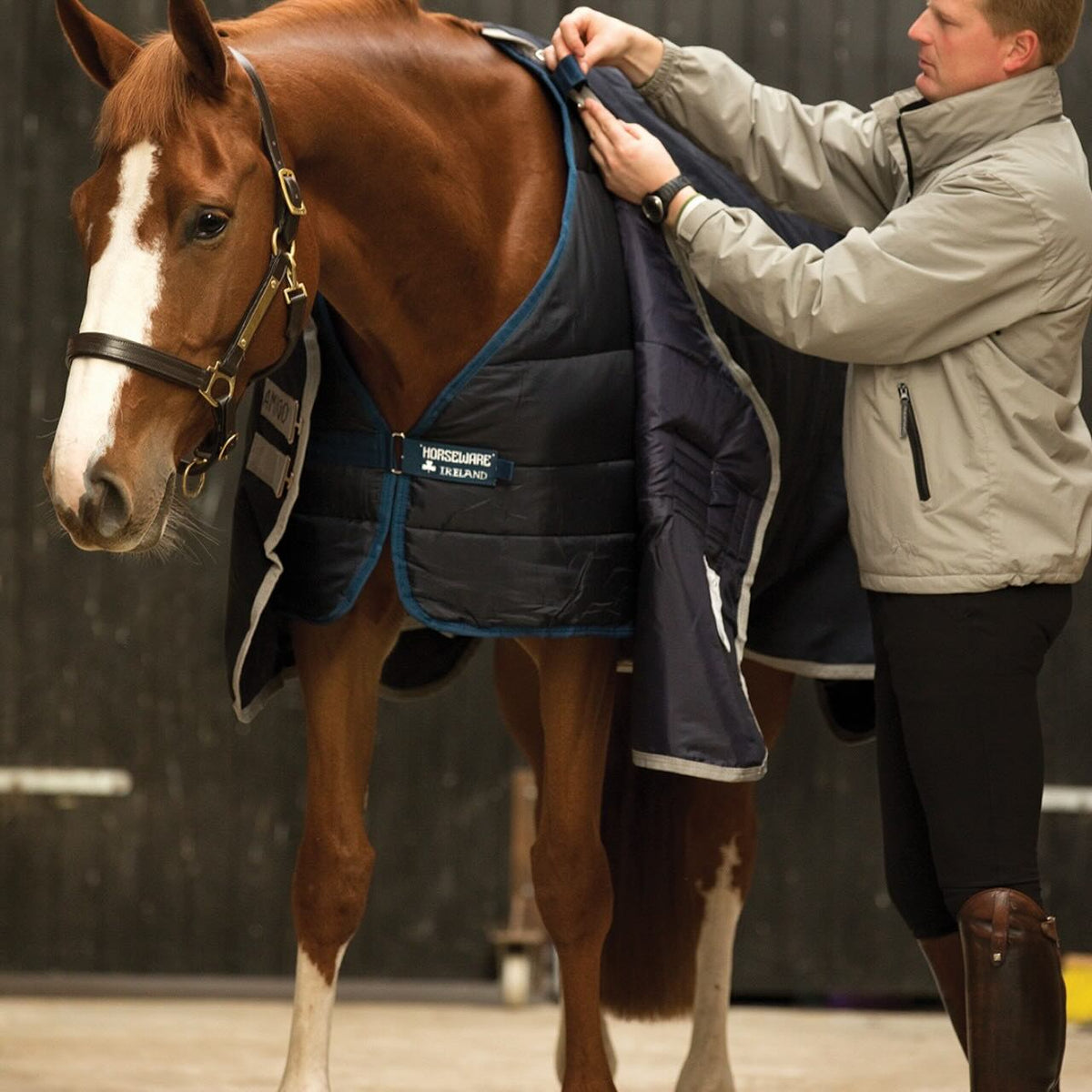 Horseware Ireland Unterdecke 100g Liner, Navy, Person legt den Liner am Pferd an.