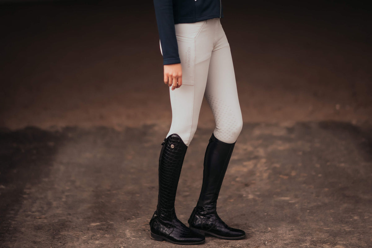 Reithose Jump Elite, Beige, an Person im Stall getragen.