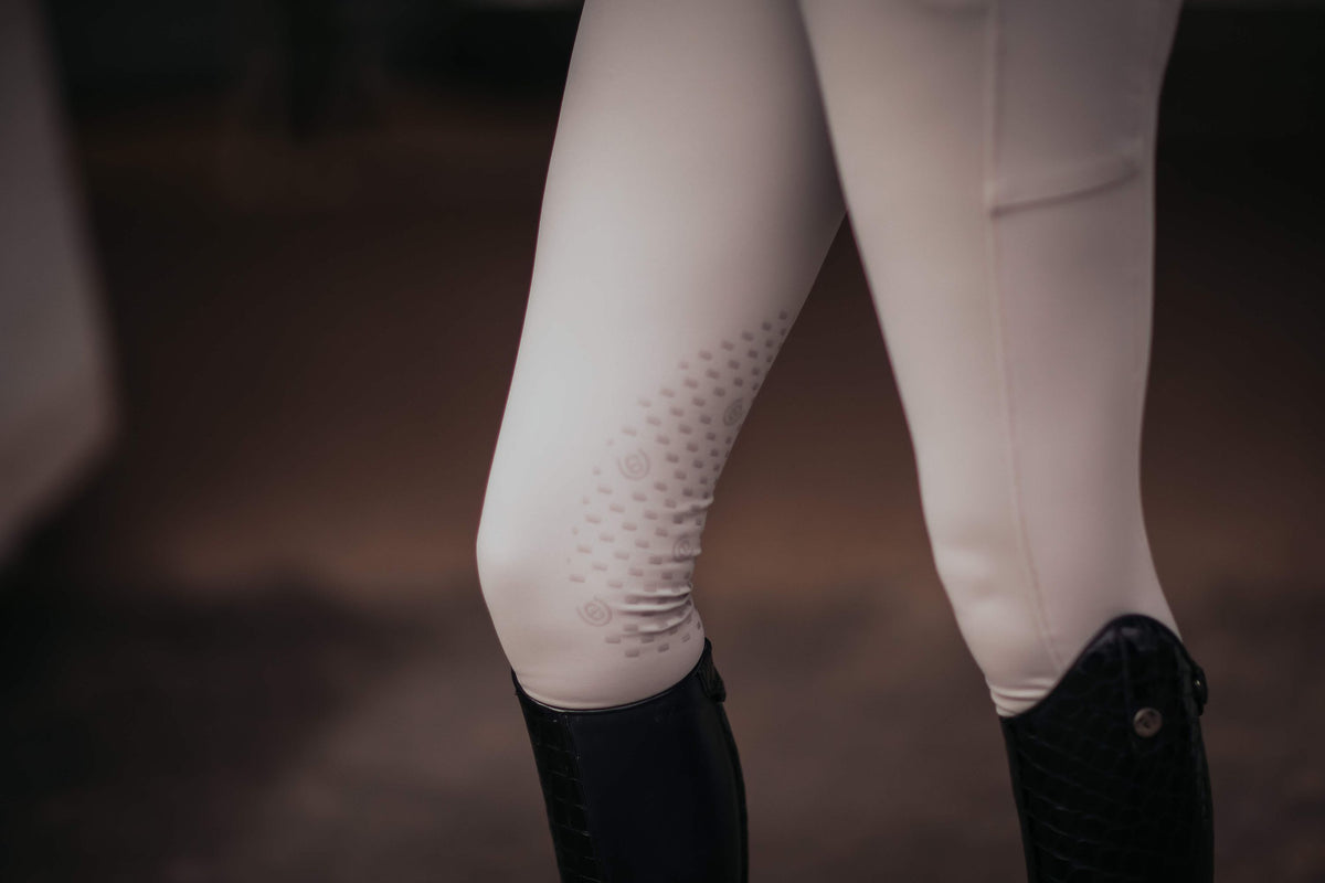 Reithose Jump Elite, Weiß, Detailaufnahme am Reiter im Stall.