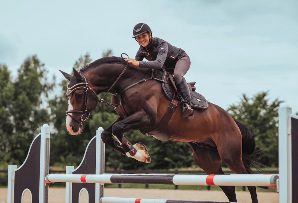 Equestrian Stockholm Springschabracke Dark Sky, Dunkelblau, Reiterin auf springendem Pferd.