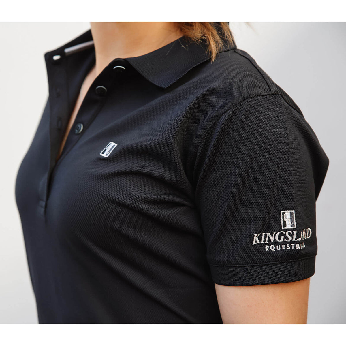 Kingsland Poloshirt Piqué Classic Damen Reitshirt, Schwarz, Detailaufnahme an Person getragen.