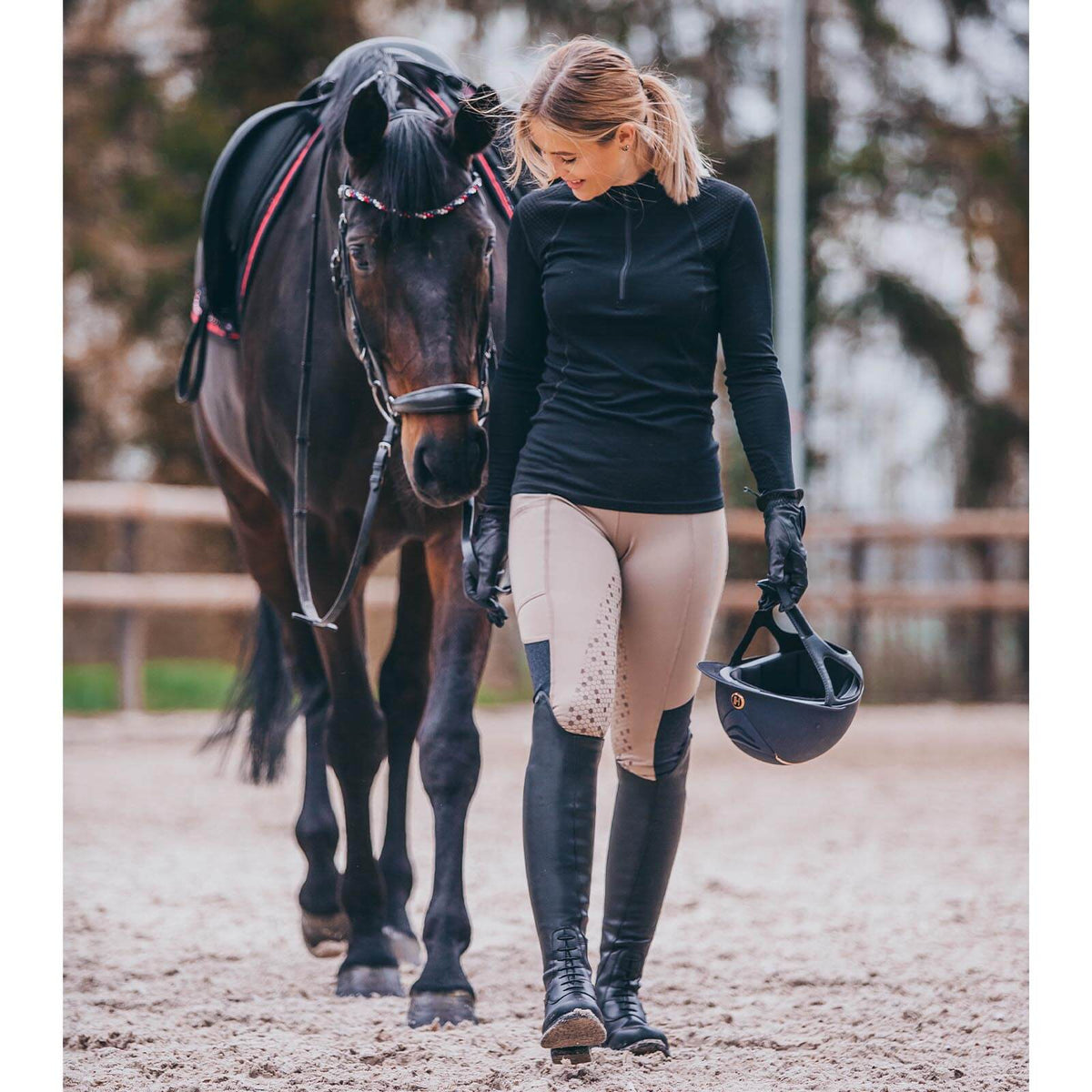 Suedwind Equestrian Reitstiefel Nova Tall Vegan, schwarz, an Reiterin im Stall.